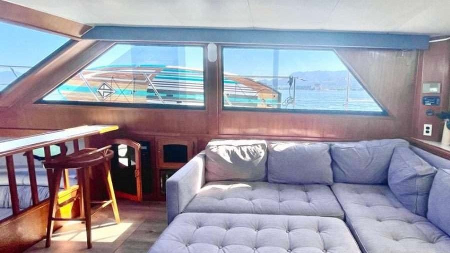 Salón interior con sala y ventanales del yate Californian 50 en Marina Vallarta, charter de yate en Puerto Vallarta para grupos